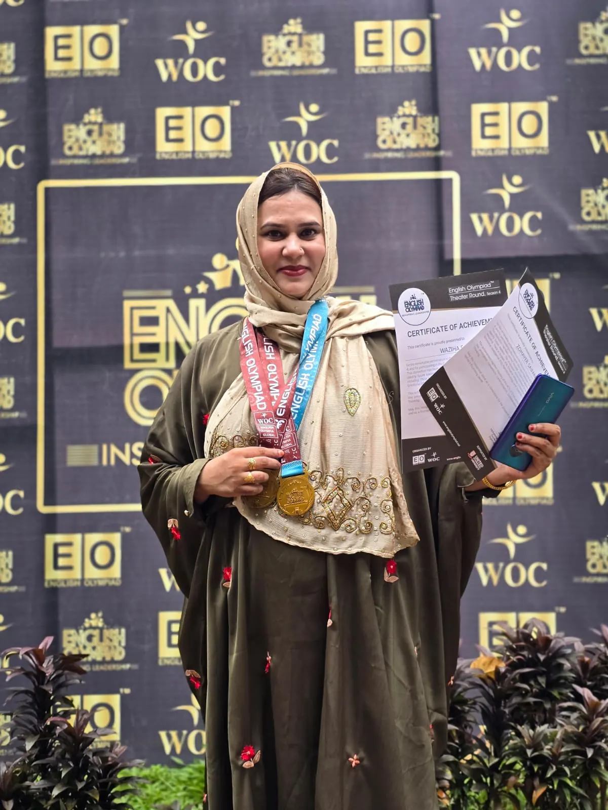 A proud guardian displaying medals at the English Olympiad
