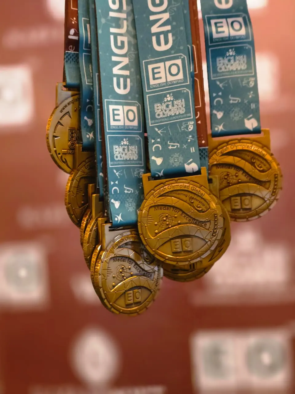Four young medalists biting their medals in celebration